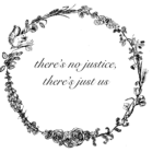 Blumenkranz mit einer Phrase in der Mitte/ Wreath of flowers with the following words in the center: "There's no justice, there's just us"